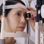 Woman taking an eye exam using an ophthalmoscope