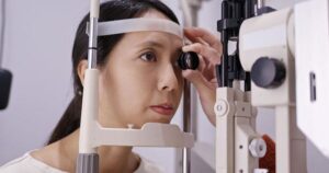 Woman taking an eye exam using an ophthalmoscope